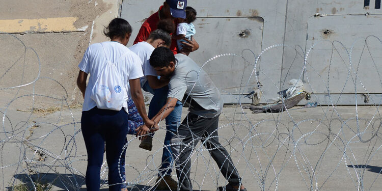 Desesperación y valentía: Migrantes atraviesan alambrada para pedir asilo en EE.UU.