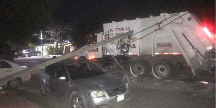Camión tumba poste que cae sobre auto.